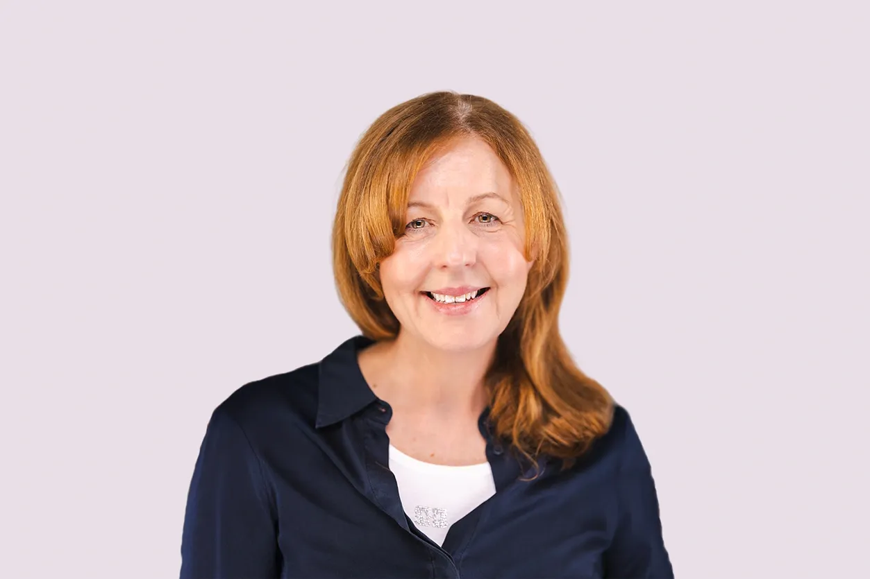 Headshot of Debbie Kennedy smiling at the camera, on a light grey background.